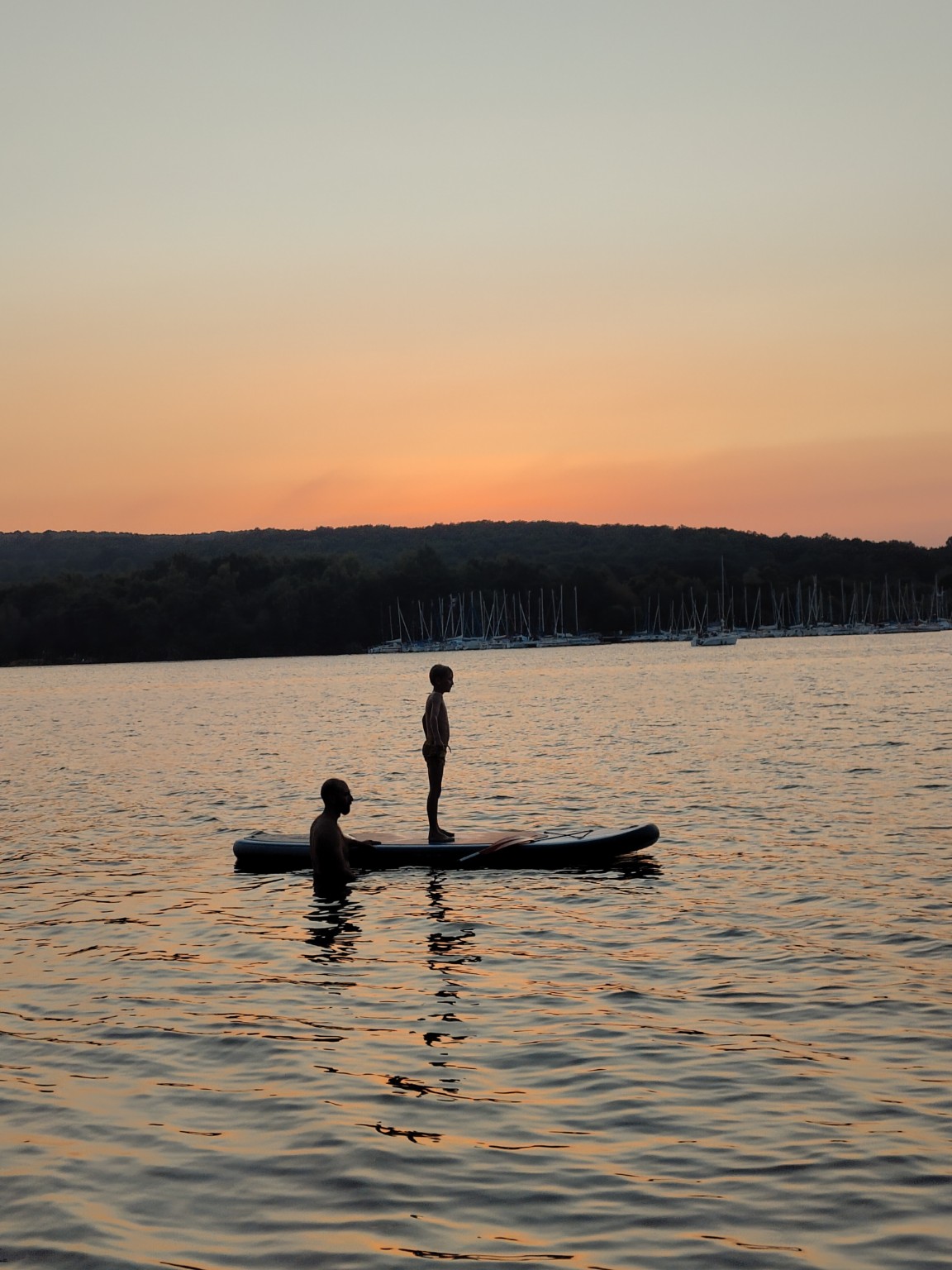 Nazareno begleitet seinen Sohn im Wasser bei Sonnenuntergang